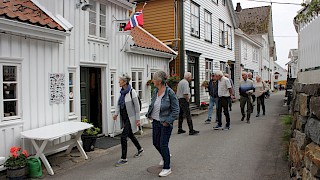 Et bilde utendørs av mennesker som vandrer langs gamle bygninger