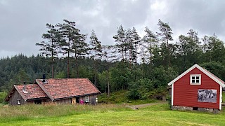 Et bilde som inneholder bygninger utendørs, gress, sky, tre