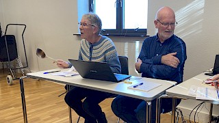 Bildet viser 2 personer rundt et møtebord