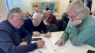 Bildet viser 3 menn som løser en quiz.